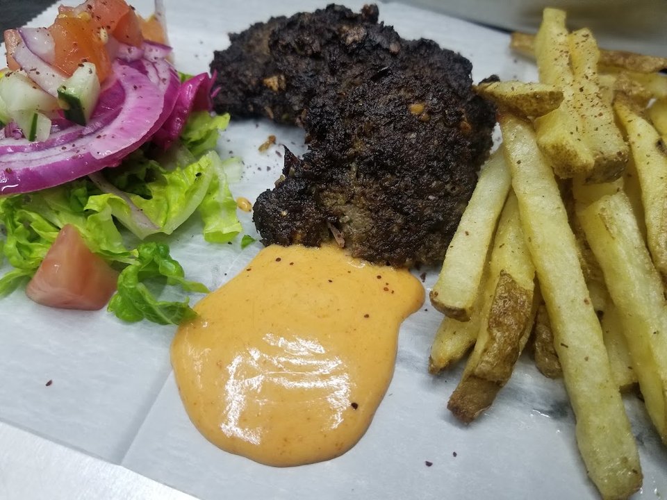Wrapped halal chapli sandwich on a tray